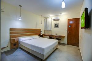 um quarto com uma cama, uma secretária e uma televisão em Spa Motel - Radial Leste em São Paulo