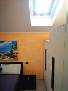 1 dormitorio con 1 cama y tragaluz en Casa in mansarda con terrazza, en Caronno Pertusella