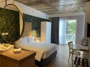 a bedroom with a bed and a sink and a mirror at Faranda Collection Barranquilla, a member of Radisson Individuals in Barranquilla