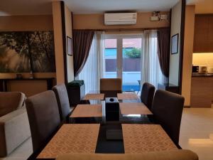 comedor con mesas y sillas y sala de estar en Midas Pool Villa en Jomtien Beach