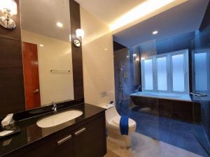 La salle de bains est pourvue d'un lavabo, de toilettes et d'un miroir. dans l'établissement Midas Pool Villa, à Jomtien Beach