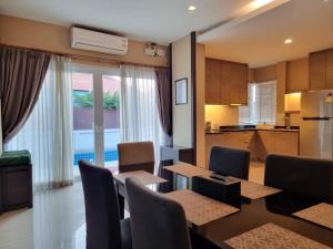 - une cuisine et une salle à manger avec une table et des chaises dans l'établissement Midas Pool Villa, à Jomtien Beach