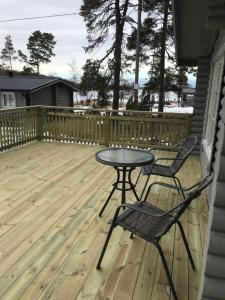 a patio with a table and chairs on a deck at Bastöstugby stuga 17 in Pålsböle