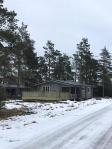 a house in the snow next to a road at Bastöstugby stuga 17 in Pålsböle