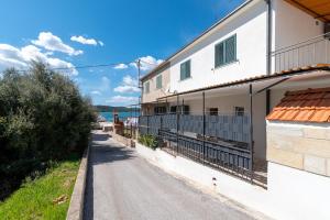 een weg voor een wit gebouw bij Apartment Radić-perfect location for summer activities in Trogir