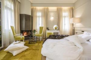 a bedroom with a bed and a desk and a fireplace at 3 Sixty Hotel & Suites in Nafplio