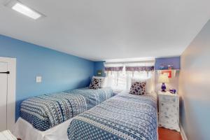two beds in a room with blue walls at The Cottage at Long Sands in York