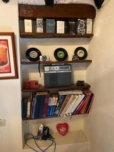 ein Regal mit Platten und Büchern an einer Wand in der Unterkunft Cabaña con excelente ubicación y zona verde. in Iza