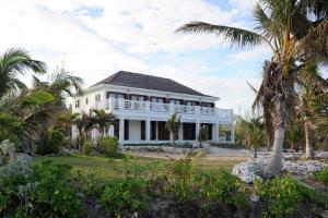 ein weißes Haus mit Palmen davor in der Unterkunft Alfred House home in Governors Harbour
