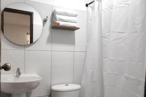 y baño con aseo, lavabo y espejo. en Ayenda Hotel Helenas, en Ríohacha