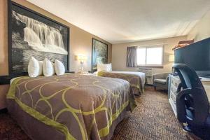 a hotel room with two beds and a television at Super 8 by Wyndham Indianapolis Emerson in Indianapolis