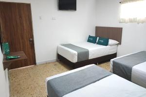 Cette chambre comprend deux lits et une télévision. dans l'établissement Ayenda Hotel Helenas, à Ríohacha