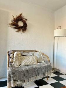 a room with a wicker chair with a wreath on the wall at Casa Carlota in Tijuana