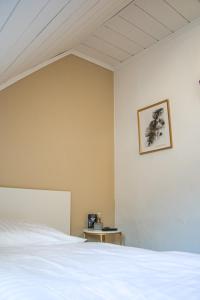 a bedroom with a white bed and a picture on the wall at Magaré Hotel & Restaurant in Lahnstein
