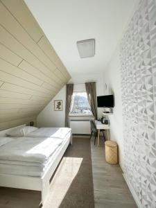 a bedroom with a white bed and a desk at Magaré Hotel & Restaurant in Lahnstein