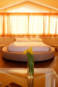 een slaapkamer met een bed en een vaas met bloemen op een tafel bij Casa di Palaia in Strada