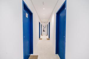 a hallway with blue doors and white walls at Pousada Villa Santô in Guarujá