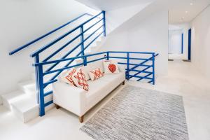 a living room with a white couch and blue railing at Pousada Villa Santô in Guarujá