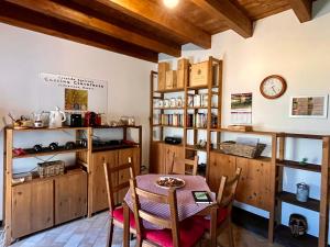 ein Esszimmer mit einem Tisch und einer Uhr an der Wand in der Unterkunft Agriturismo Cascina Clavarezza in Valbravenna
