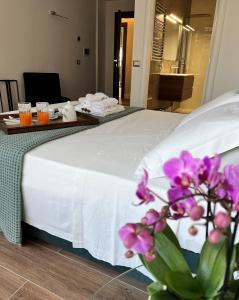 a hotel room with a white bed with purple flowers at Alèa Rooms in Lecce