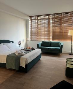 a bedroom with a large bed and a couch at Alèa Rooms in Lecce