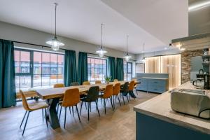 a kitchen and dining room with a long table and chairs at vila FABRIKA in Vyhne