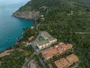 una vista aérea de una casa en una colina junto al agua en Affitti Brevi Toscana - A pochi passi dal Mare, en Talamone