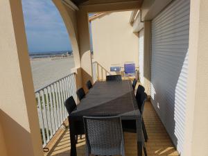 balkon ze stołem i krzesłami na plaży w obiekcie CARNON - T4 1ére ligne w mieście Mauguio
