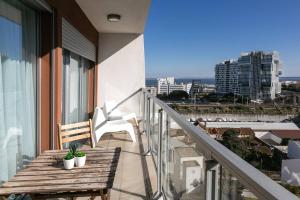 balcón con banco de madera y vistas a la ciudad en Lisbon Metro & Pool Apartment, en Lisboa