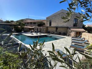 una piscina con tumbonas y una casa en Hôtel Casa Rossa & Spa, en LʼÎle-Rousse