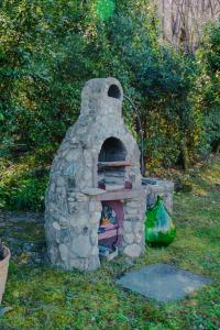 a stone oven sitting in the grass in a yard at Villa Oliveto apartments in Oliveto Lario