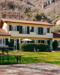 a yellow house with a picnic table in front of it at Villa Oliveto apartments in Oliveto Lario