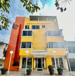 een geel en oranje gebouw met een klok erop bij OYO Hotel Puerto Real Coatzacoalcos in Coatzacoalcos
