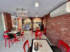 een eetkamer met rode stoelen en een bakstenen muur bij OYO Hotel Puerto Real Coatzacoalcos in Coatzacoalcos