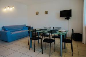 sala de estar con mesa, sillas y sofá en Villa Oliveto apartments, en Oliveto Lario