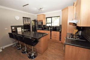 a kitchen with a bar with black counter tops at Elroys in Sandton