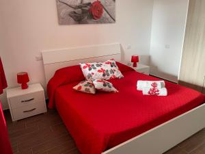 ein Schlafzimmer mit einem roten Bett mit Kissen und roten Lampen in der Unterkunft Villetta Capo Comino 500 m DAL MARE in Siniscola