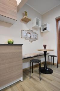 a kitchen with a table and two stools at Kosentia Bed and Breakfast in Cosenza +4 photos