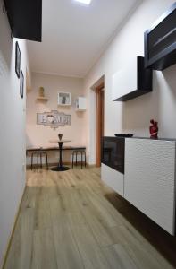 a kitchen with white cabinets and a wooden floor at Kosentia Bed and Breakfast in Cosenza