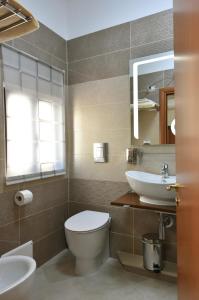 ein Badezimmer mit einem WC, einem Waschbecken und einem Spiegel in der Unterkunft Kosentia Bed and Breakfast in Cosenza