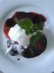 a dessert on a white plate with ice cream and blackberries at The Trails Retreat (Private Cabin) in Orangeville