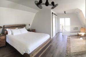 a bedroom with a large white bed and a chair at The Trails Retreat (Private Cabin) in Orangeville