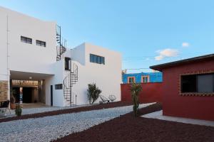 a house with white walls and a red building at Posada Independencia in Oaxaca City