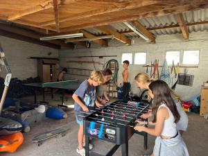 a group of people playing a game with a ping pong table at Witbaai Beach House in Britannia Bay