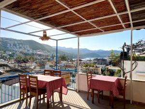 balcón con mesas y sillas y vistas a la ciudad en Salina Pansiyon, en Kas