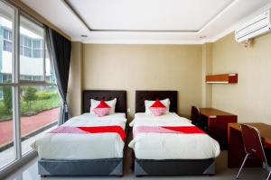 Postel nebo postele na pokoji v ubytování Super OYO Collection O 3431 Hotel Alpha Bandara