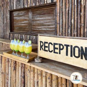 a sign that says reception with three drinks on a shelf at TSIAZOMPANIRY ISLAND LODGE 