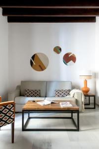 - un salon avec un canapé et une table basse dans l'établissement Triana Boutique Apartments by Hommyhome, à Séville