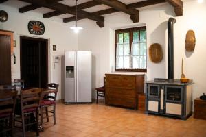 a kitchen with a refrigerator and a table and chairs at VILLA LIA, casa in collina con piscina. in Porello