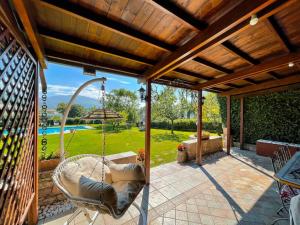 a porch with a swing and a view of a yard at VILLA LIA, casa in collina con piscina. in Porello